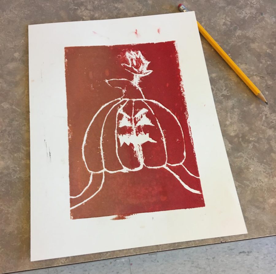A red print that is a Jack-O-Lantern  by Chris Denney. 