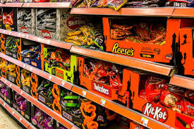 Halloween candy stacked on shelf. 
