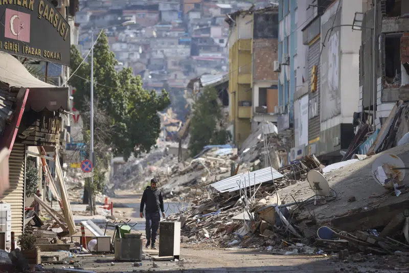 A man walks past destroyed buildings in Antakaya 