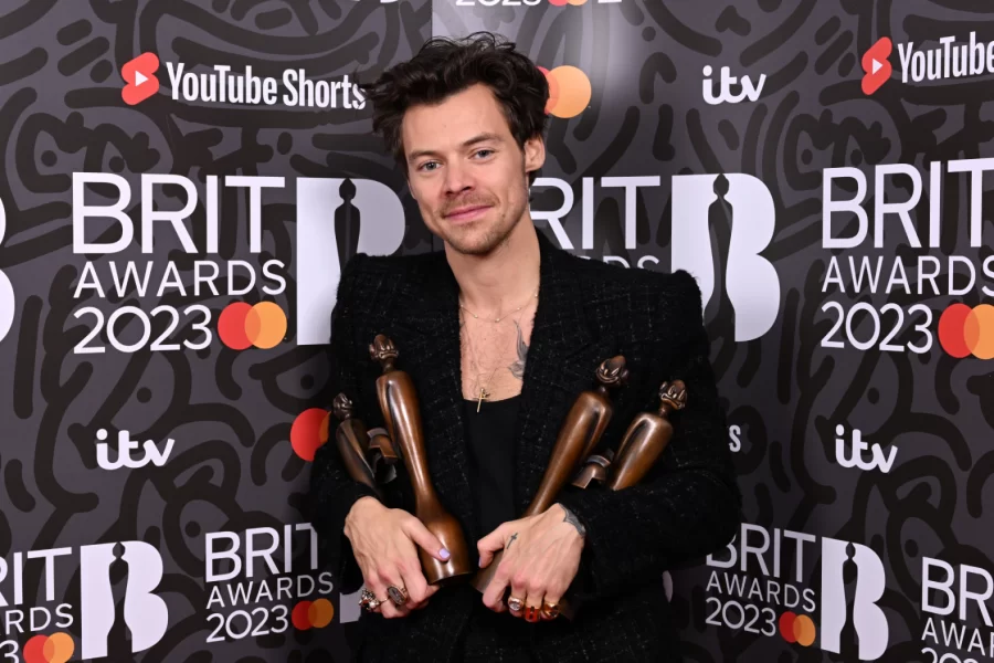 Harry Styles holding his four awards that he won at the 2023 Brits Awards.
