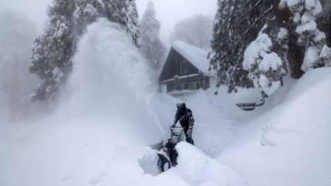 This is a photo of someone in the snow trying to clear a walkway.