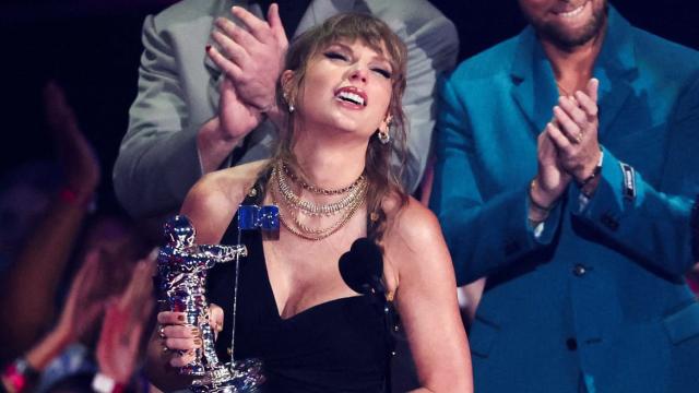 Taylor Swift up on stage with her reward given by the band NSYNC for best pop video for her song Anti-Hero , whilst fangirling over the bands long awaited reunion. 