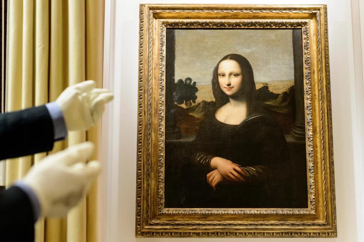 A picture of the infamous painting, The Mona Lisa which features a pair of hands about to touch it. 