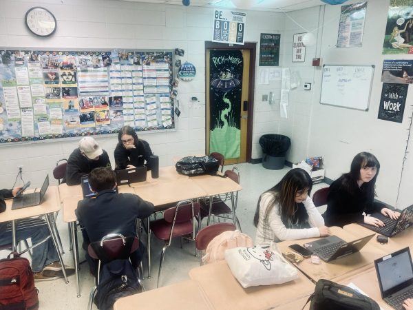 This photo pictures high school students using their devices to complete their daily schoolwork. 