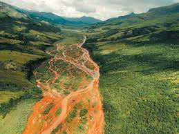 Birds eye view of a river that has become orange due to rusting . 