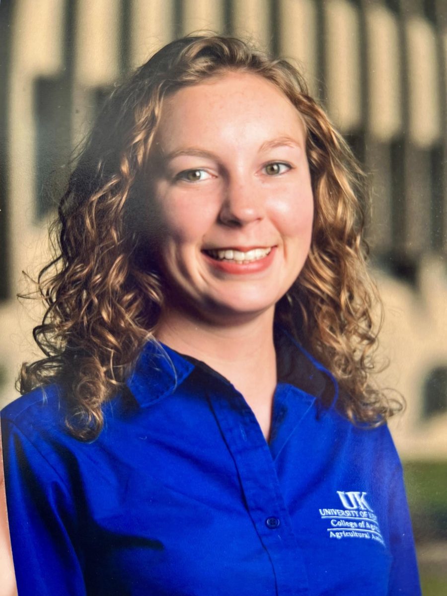 Cecilia smiles big for a picture in her University of Kentucky, College of Agriculture polo. 