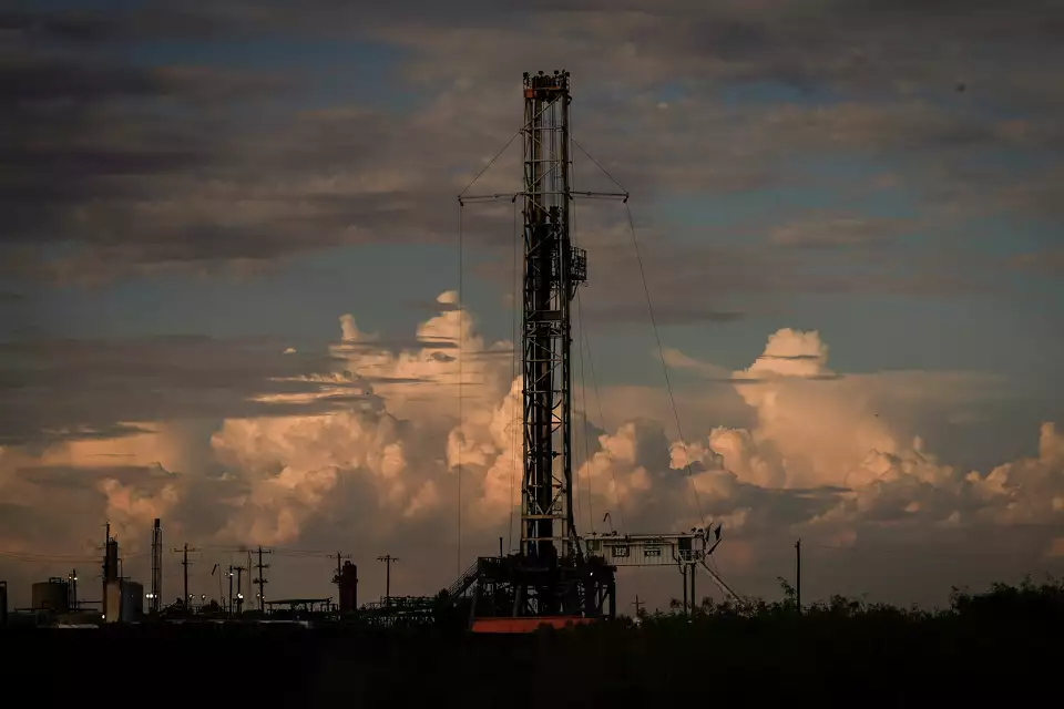 A drilling rig operating as the sun sets.