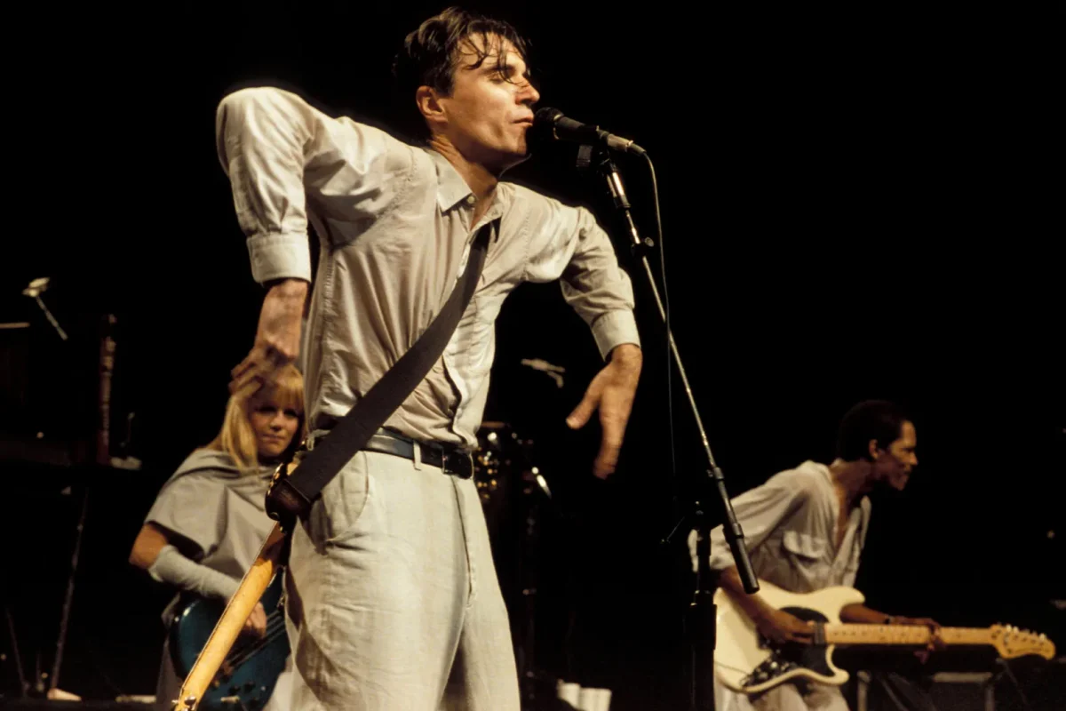 Talking Heads singer David Byrne dancing erratically while singing on stage.